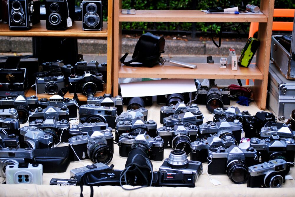 black and silver dslr camera on brown wooden shelf